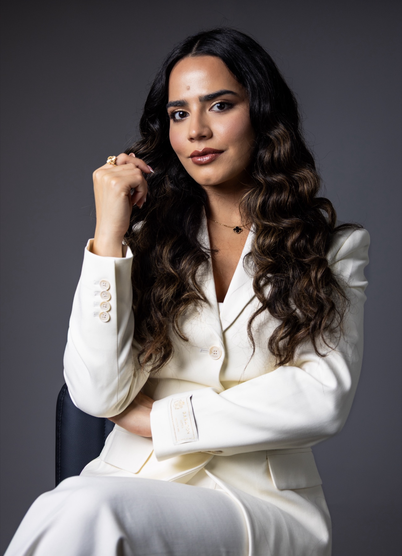 Julymar D'Lima, estratega de marca personal y monetización, en retrato de estudio con traje crema.